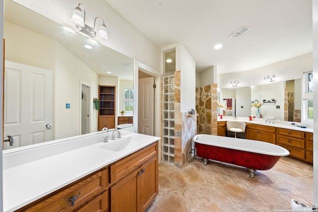 bathroom featuring a tub, vanity, and tile patterned flooring