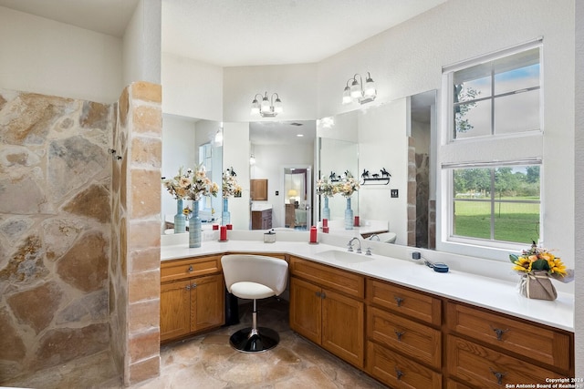 full bath with a shower, stone finish flooring, and vanity