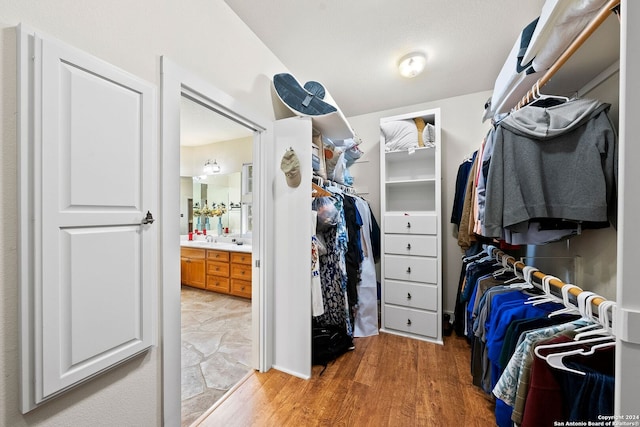 spacious closet featuring hardwood / wood-style floors and sink