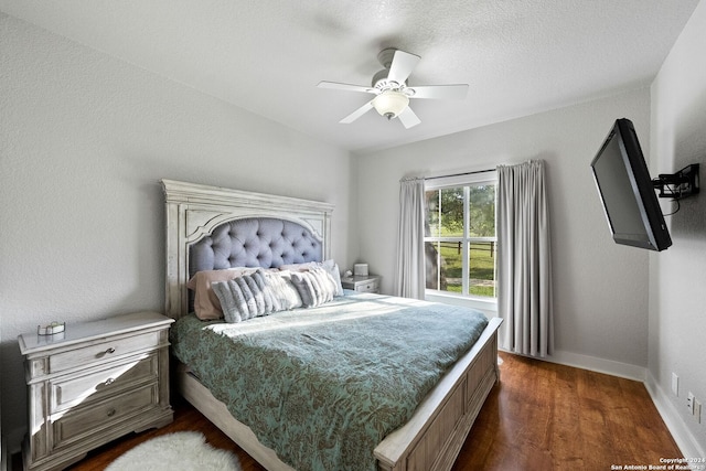 bedroom with a textured ceiling, ceiling fan, and dark wood-type flooring