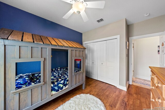 bedroom featuring dark hardwood / wood-style flooring, a closet, and ceiling fan