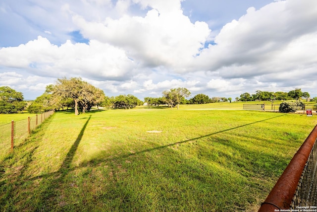 view of yard with a rural view and fence