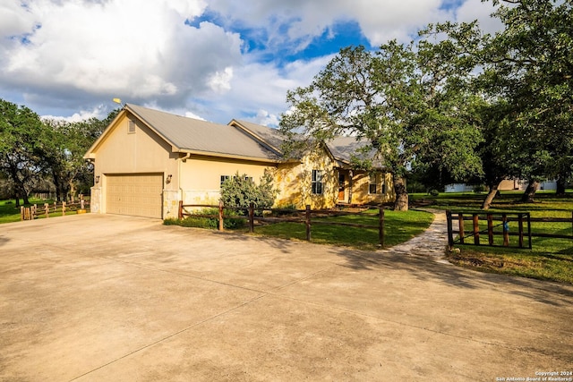 view of property exterior with stone siding, a fenced front yard, concrete driveway, and a yard