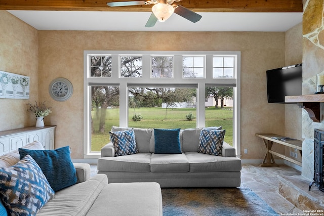 living room featuring a high ceiling, a ceiling fan, baseboards, beam ceiling, and stone finish flooring