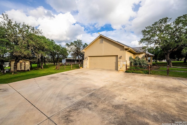 view of front facade with stucco siding, concrete driveway, fence, a garage, and a front lawn