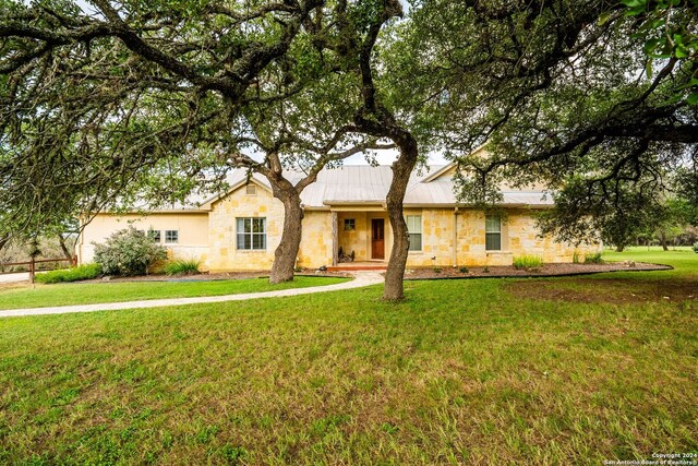 single story home featuring a front lawn