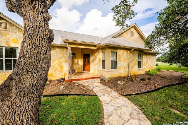 view of front of house with metal roof and stone siding