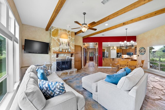 tiled living room featuring beam ceiling, a fireplace, and ceiling fan with notable chandelier