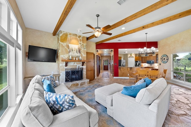 living area with beam ceiling, visible vents, a stone fireplace, and ceiling fan with notable chandelier