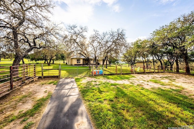 exterior space featuring a gate, a rural view, and fence