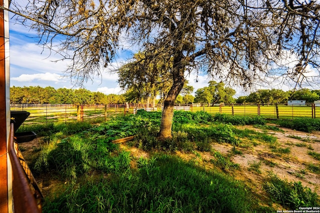 view of yard with a rural view and fence