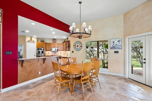 dining space with a chandelier, a high ceiling, recessed lighting, and baseboards