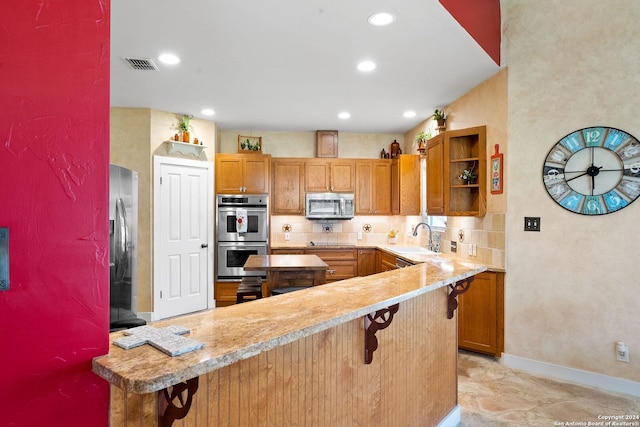 kitchen with a kitchen bar, kitchen peninsula, tasteful backsplash, and stainless steel appliances