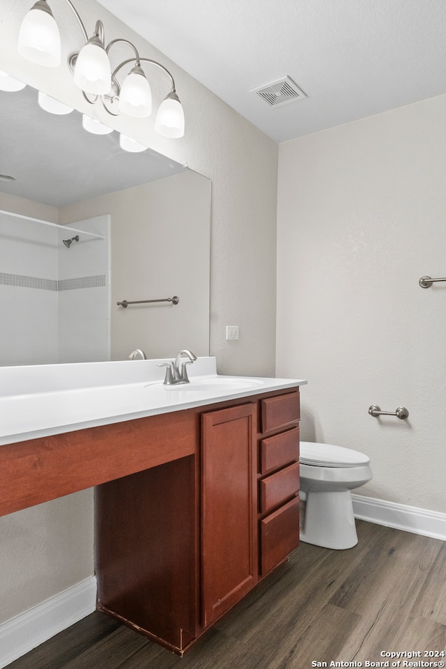 bathroom with hardwood / wood-style flooring, toilet, and vanity