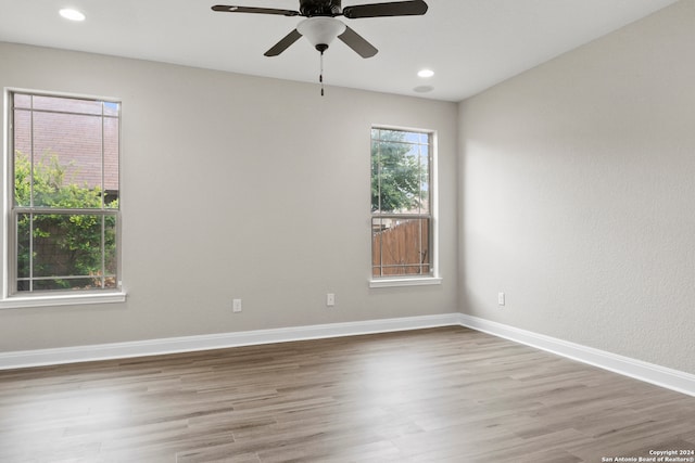 unfurnished room featuring plenty of natural light, ceiling fan, and hardwood / wood-style floors