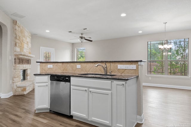 kitchen with light hardwood / wood-style floors, tasteful backsplash, sink, and stainless steel dishwasher