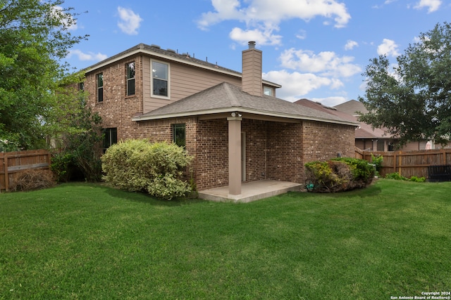 rear view of property with a yard