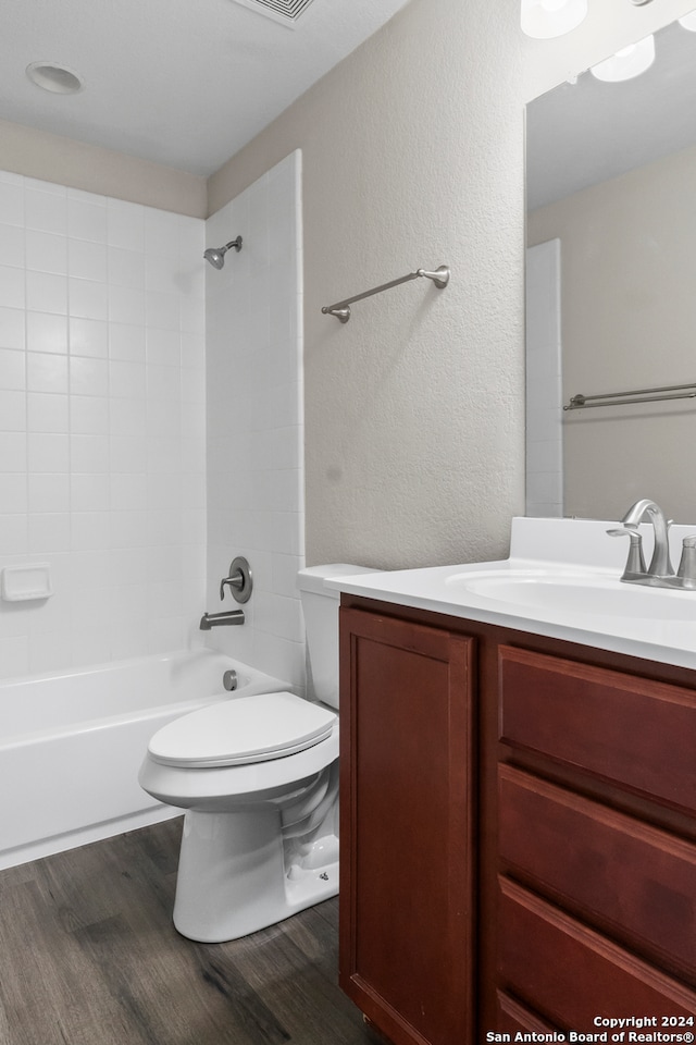 full bathroom with bathing tub / shower combination, vanity, wood-type flooring, and toilet