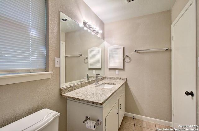 bathroom with toilet, tile patterned floors, and vanity