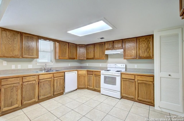 kitchen featuring white appliances, light tile patterned floors, and sink