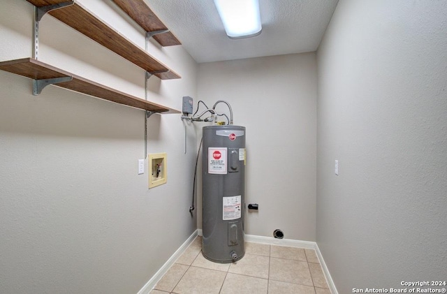 interior space featuring electric dryer hookup, water heater, washer hookup, and light tile patterned floors