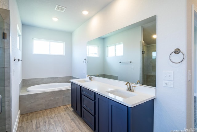 bathroom with wood-type flooring, vanity, and separate shower and tub