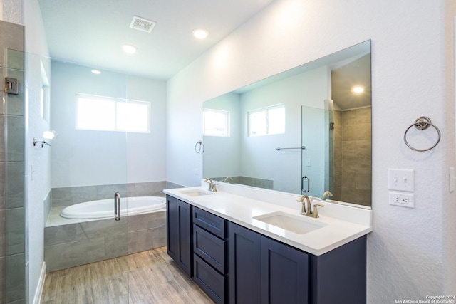 bathroom with shower with separate bathtub, vanity, and wood-type flooring