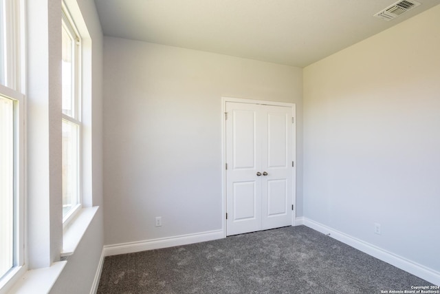 unfurnished room with dark carpet