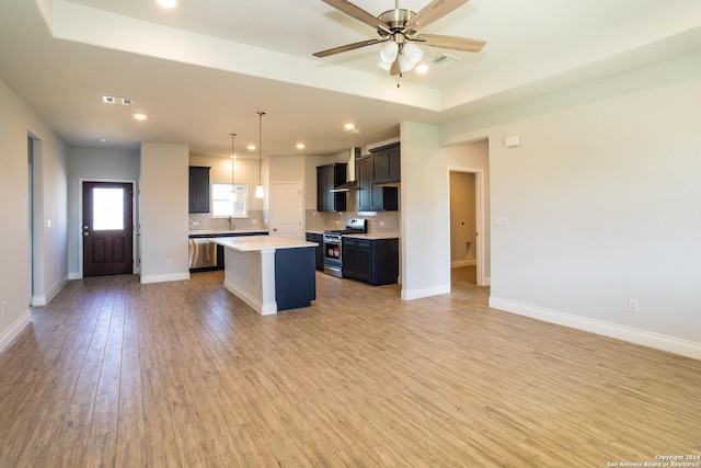 kitchen with stainless steel appliances, a center island, light wood-type flooring, decorative backsplash, and pendant lighting