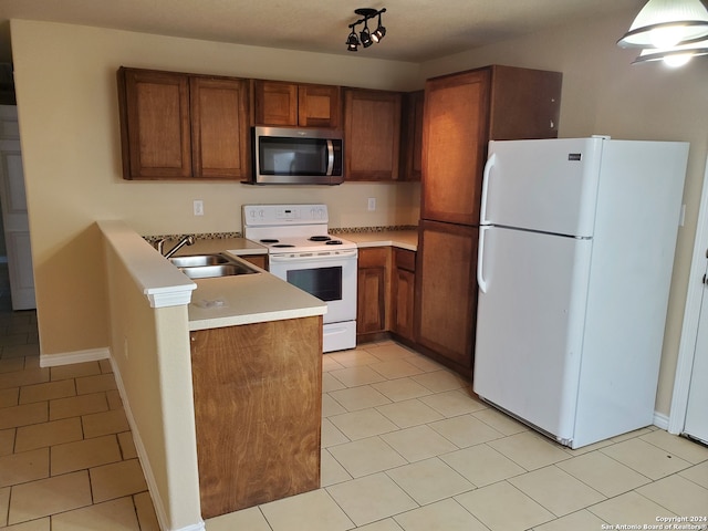 kitchen featuring light tile patterned floors, rail lighting, white appliances, and sink