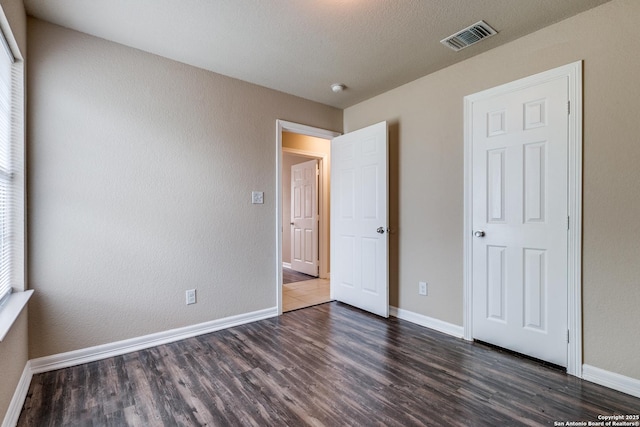 203 Carranza St, San Antonio, TX 78225 - unfurnished bedroom with dark wood finished floors and baseboards