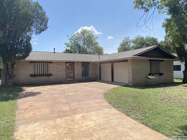 ranch-style house featuring brick siding, concrete driveway, and a front lawn