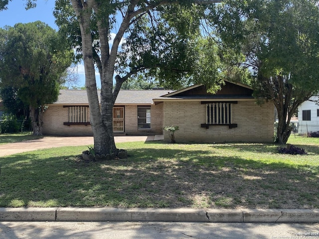 single story home with brick siding, concrete driveway, and a front yard