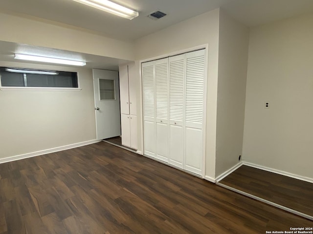 unfurnished bedroom featuring a closet and dark hardwood / wood-style flooring