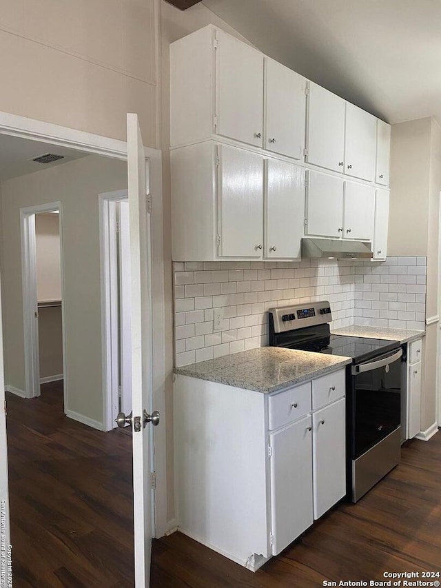 kitchen with white cabinets, dark hardwood / wood-style flooring, backsplash, and electric stove