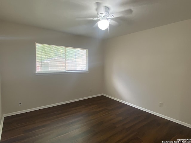 unfurnished room featuring dark wood-type flooring and ceiling fan