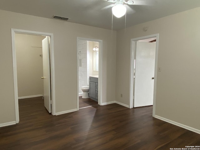 unfurnished bedroom with ensuite bath, ceiling fan, and dark hardwood / wood-style flooring