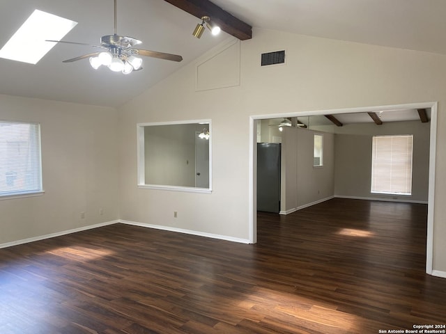 empty room with lofted ceiling with skylight, dark hardwood / wood-style flooring, and ceiling fan