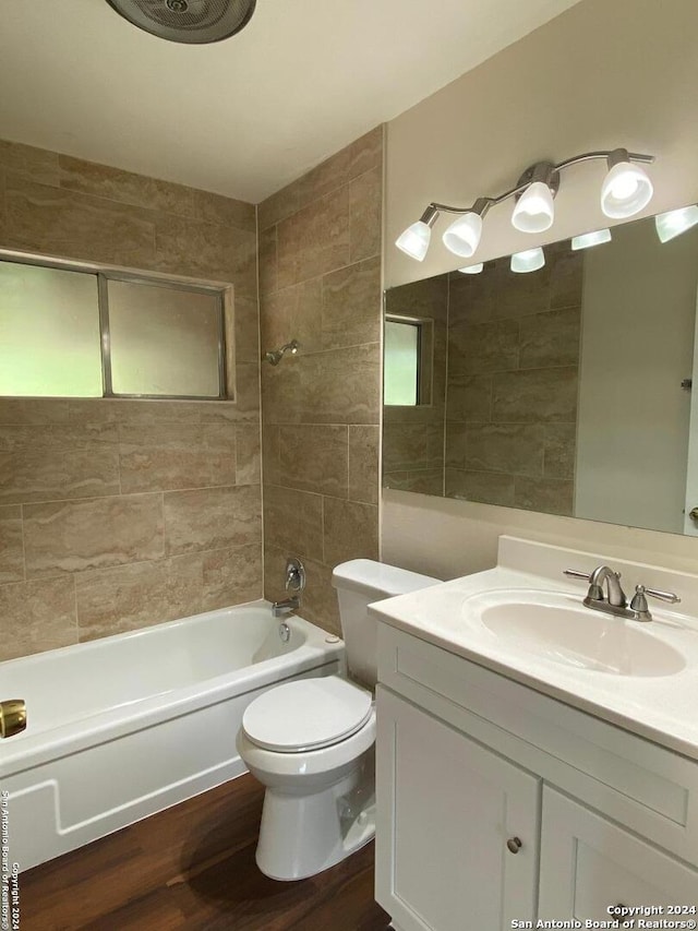 full bathroom with vanity, toilet, tiled shower / bath combo, and hardwood / wood-style flooring