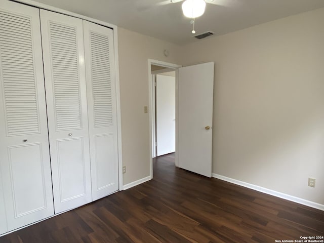 unfurnished bedroom featuring ceiling fan, dark hardwood / wood-style flooring, and a closet