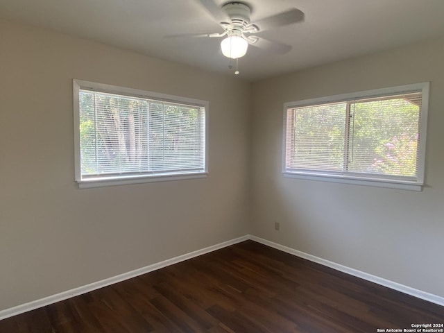 unfurnished room featuring dark wood-type flooring and ceiling fan