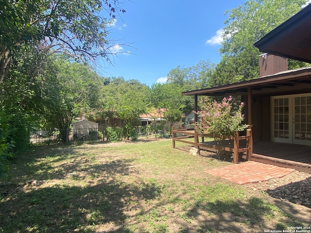 view of yard featuring french doors and a wooden deck