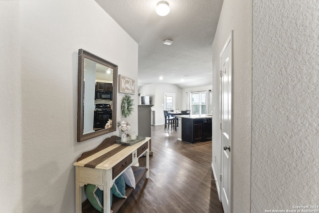 hall featuring a textured ceiling and dark wood-type flooring