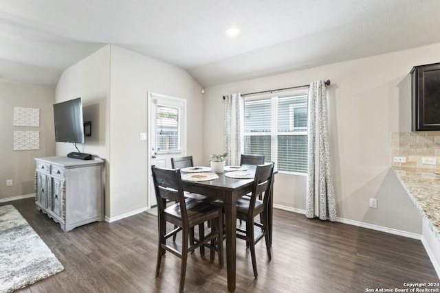 dining room featuring vaulted ceiling and dark hardwood / wood-style flooring