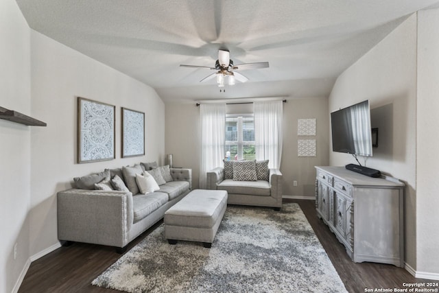 living room featuring vaulted ceiling, dark wood-type flooring, a textured ceiling, and ceiling fan