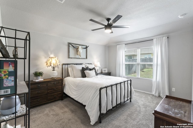 bedroom with ceiling fan, light colored carpet, a textured ceiling, and lofted ceiling