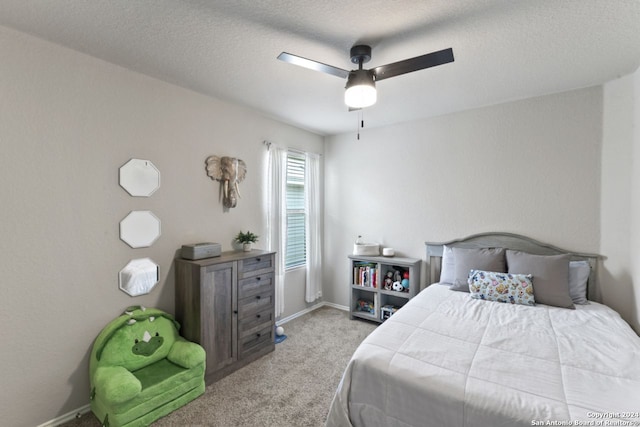 bedroom with ceiling fan, a textured ceiling, and light carpet