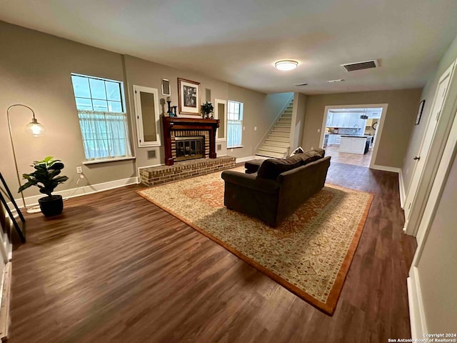 living room with dark wood-type flooring and a fireplace