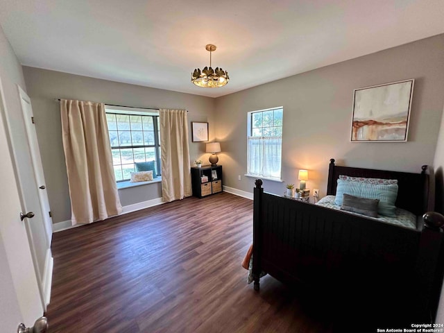 bedroom featuring a chandelier and dark hardwood / wood-style floors