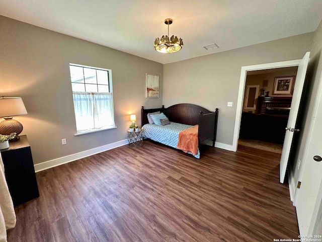 bedroom featuring a chandelier and dark hardwood / wood-style floors